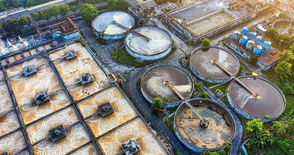Vista aérea de estação de tratamento de água industrial com decantadores circulares